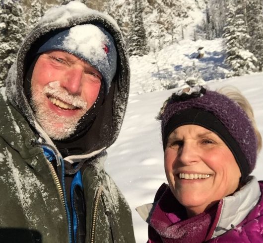Innkeepers John and Jill in snow, smiling for camera