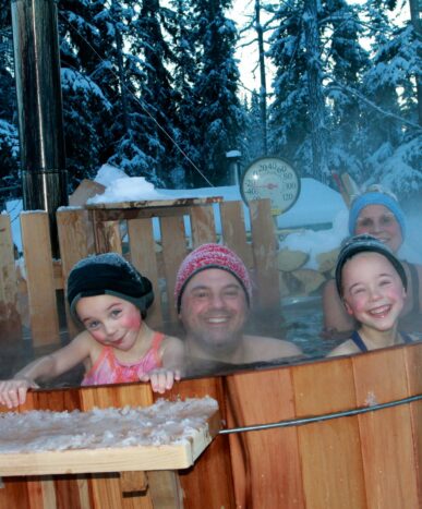 Family in hot tub surrounded by snow