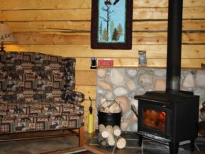 Woodburning stove in Eagle's Nest cabin with comfy chair for relaxing by fire