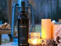 Bottle of wine near candles and lantern
