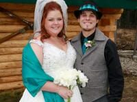 Bride and groom in front of cabin