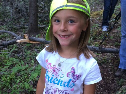 Smiling girl with green hat on sidewards